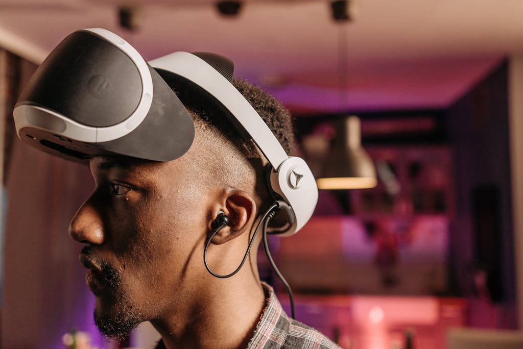 Close-up of a man wearing a virtual reality headset and earphones indoors.