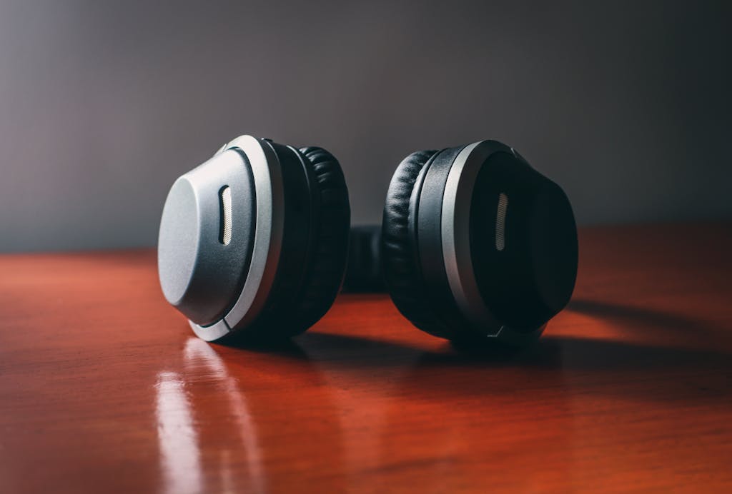 Close-up of sleek wireless headphones on a wooden surface, perfect for music enthusiasts.